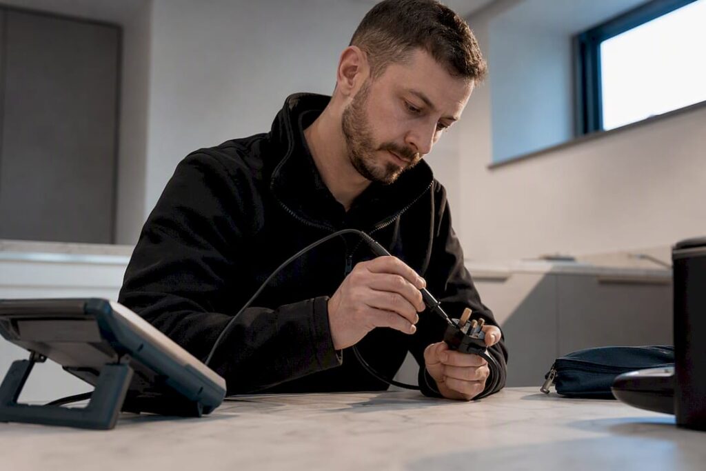 Technician carrying out portable appliance testing